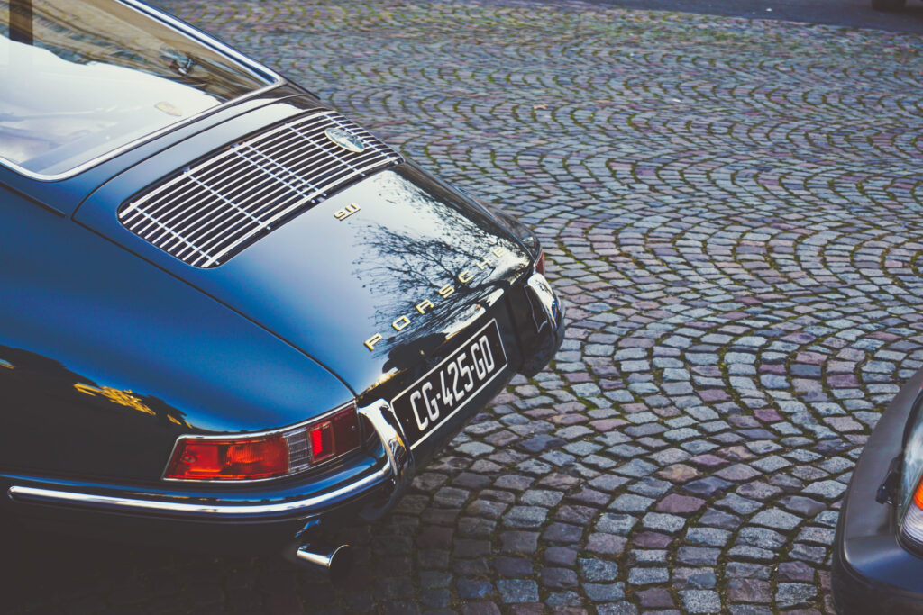 Elegant Vintage Porsche 911 Rear View Wallpaper on Cobblestone Background