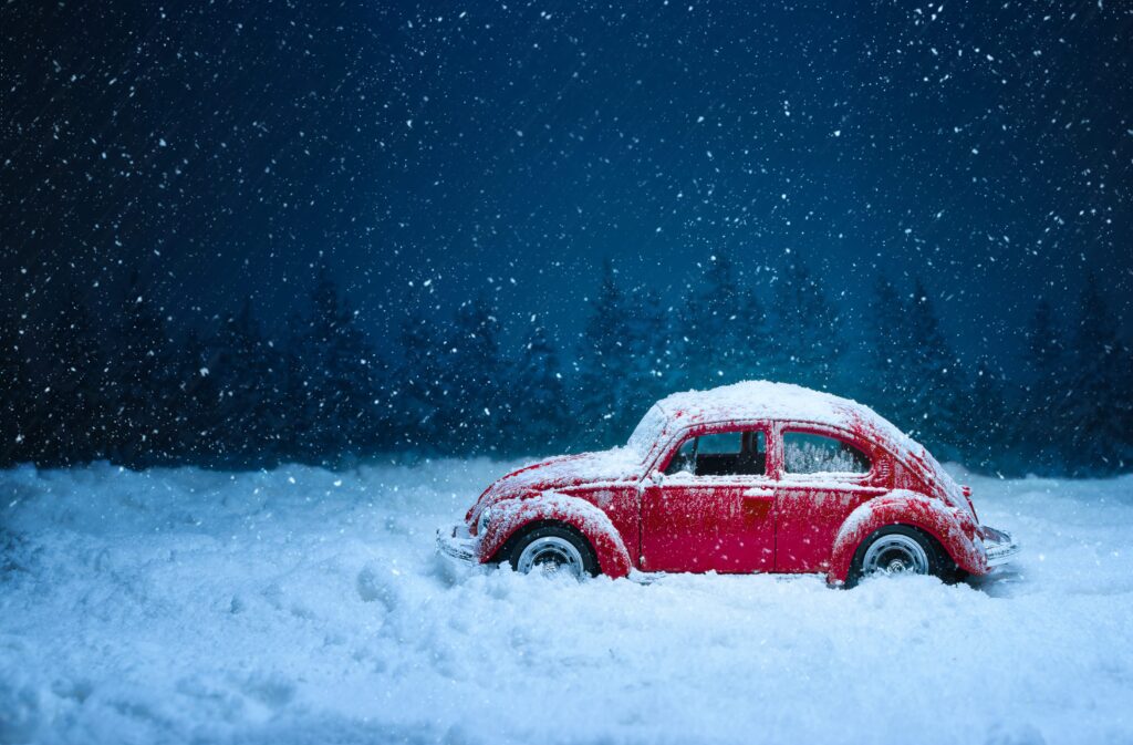 Nostalgic Vintage Red Car in Serene Snowy Evergreen Landscape Wallpaper