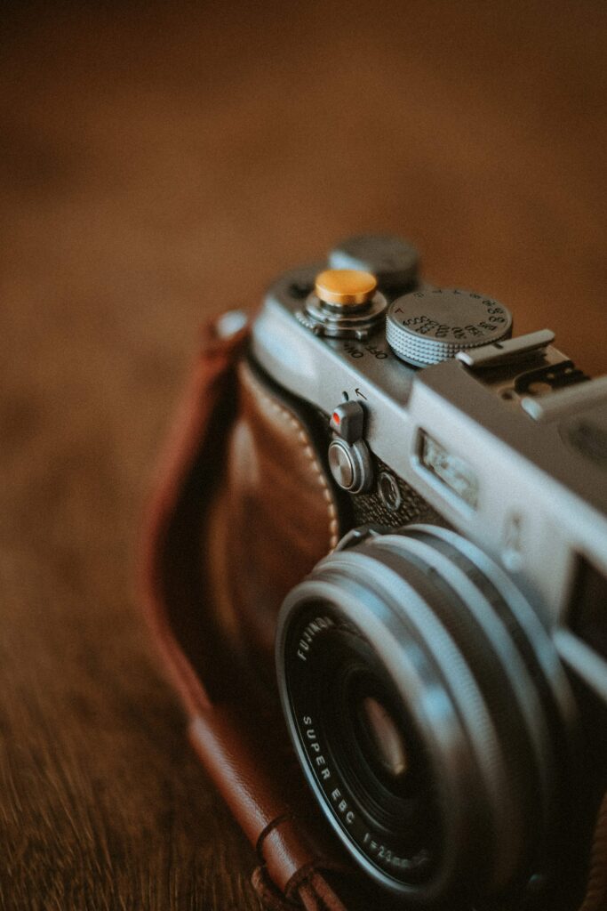 Close-up macro of vintage retro camera with metal dials textured surfaces warm lighting wallpaper