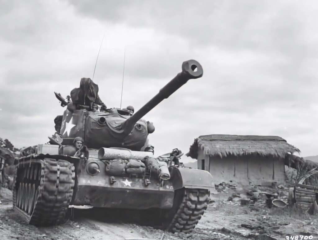 Vintage Tank on Dirt Road Past Rustic Buildings - Historical Scene Wallpaper