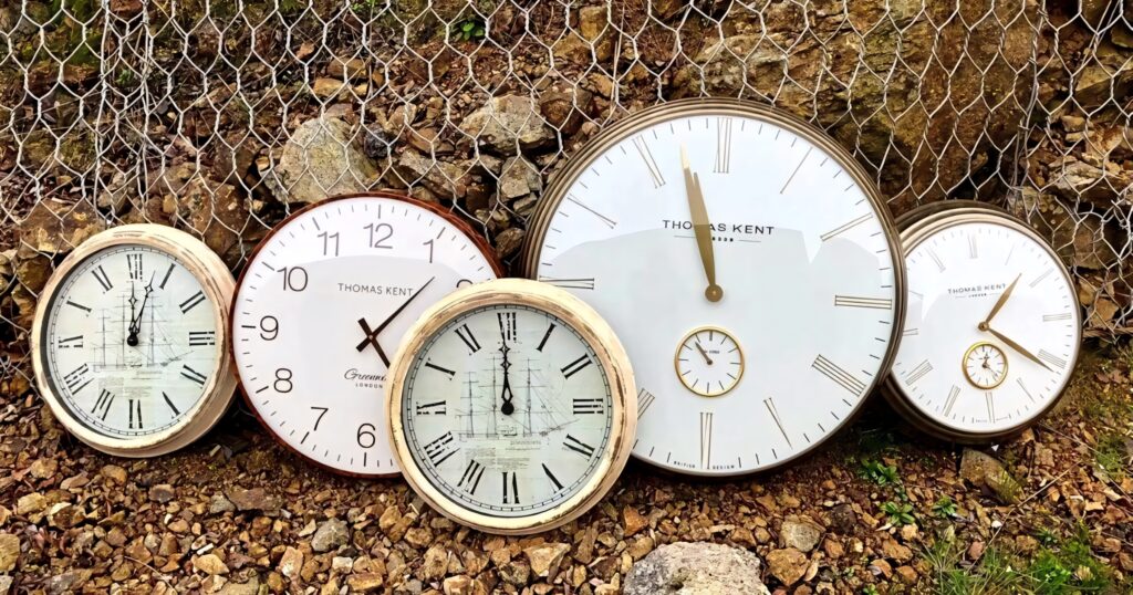 Elegant Thomas Kent wall clocks on rustic stone and wire background vintage classic design Wallpaper