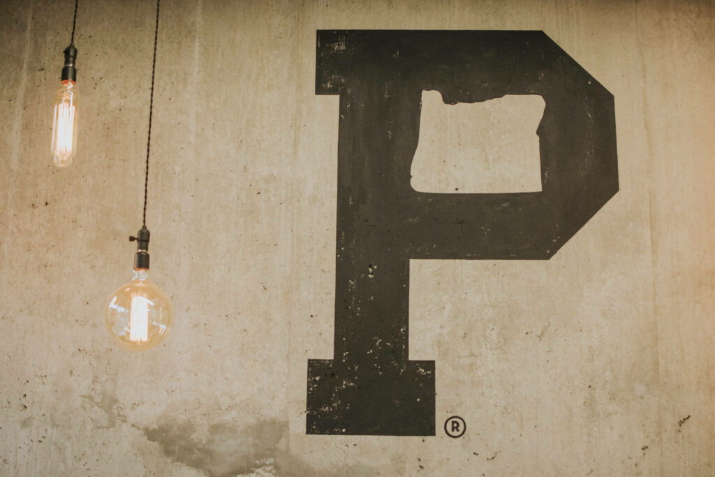 Vintage Black Letter P Wallpaper on Textured Beige with Edison Bulbs