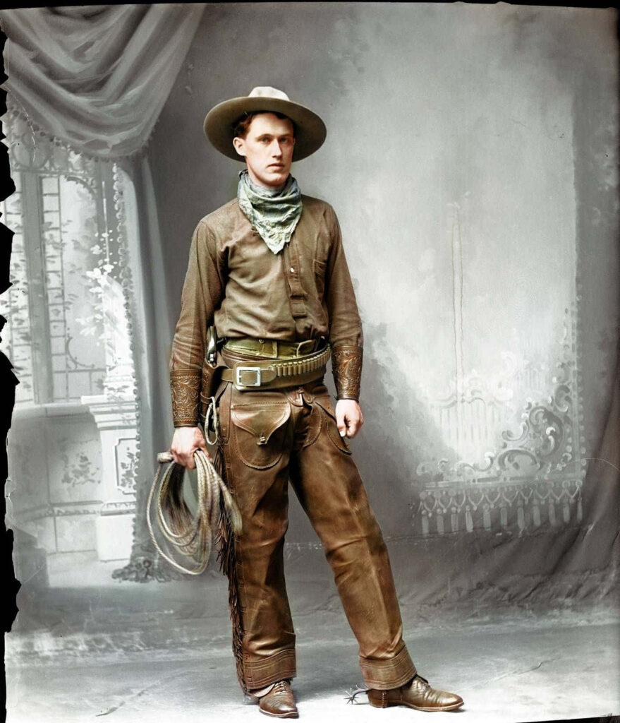 Vintage wallpaper of stoic cowboy in leather attire with rope and wide-brimmed hat sepia tone