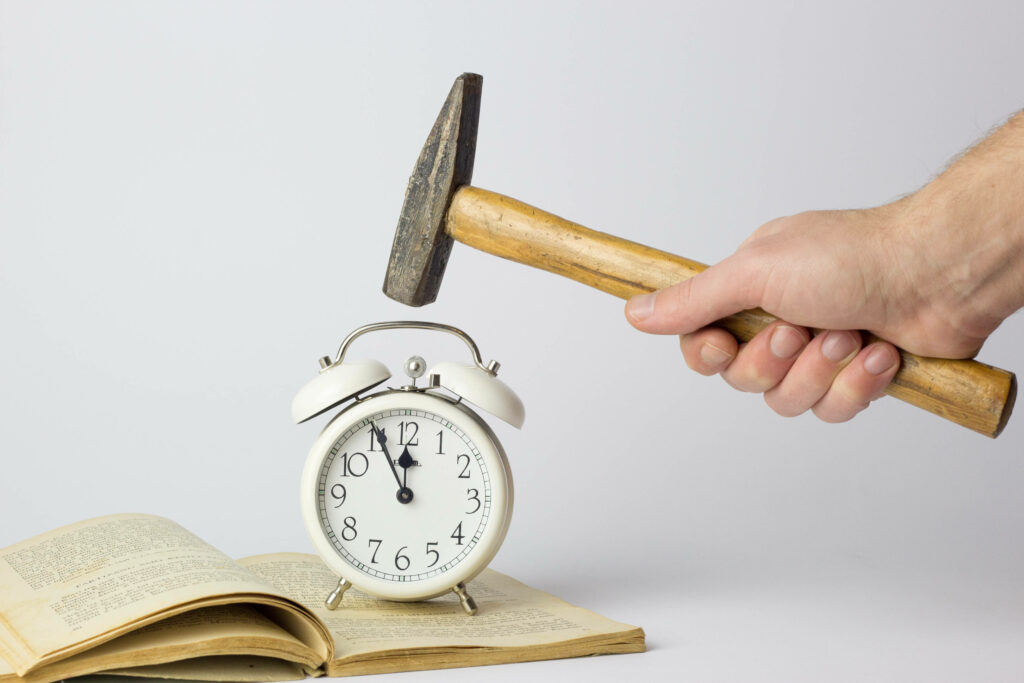 White vintage clock on open book with hammer poised above symbolizing time and urgency Wallpaper