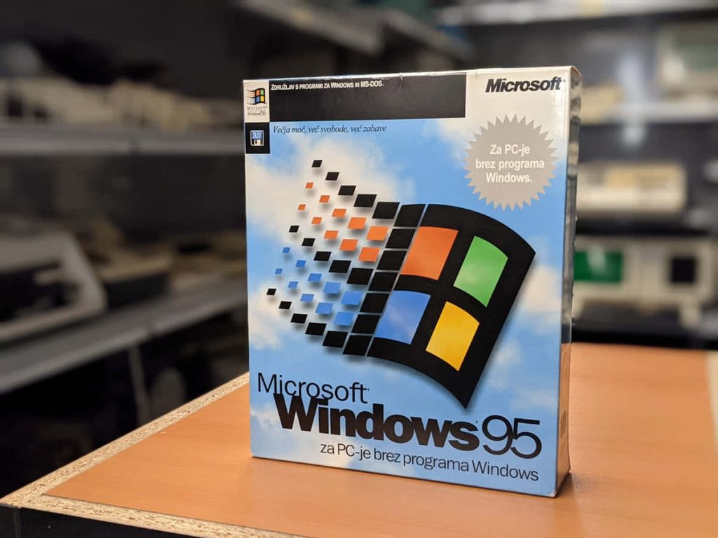 Vintage Windows 95 retail box with colorful logo on desk, nostalgic 90s computing packaging Wallpaper