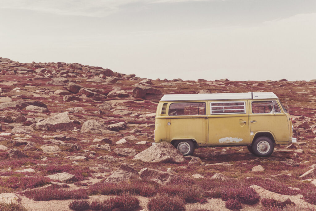 Vintage Yellow Bus in Rugged Landscape: A Scenic Adventure Wallpaper