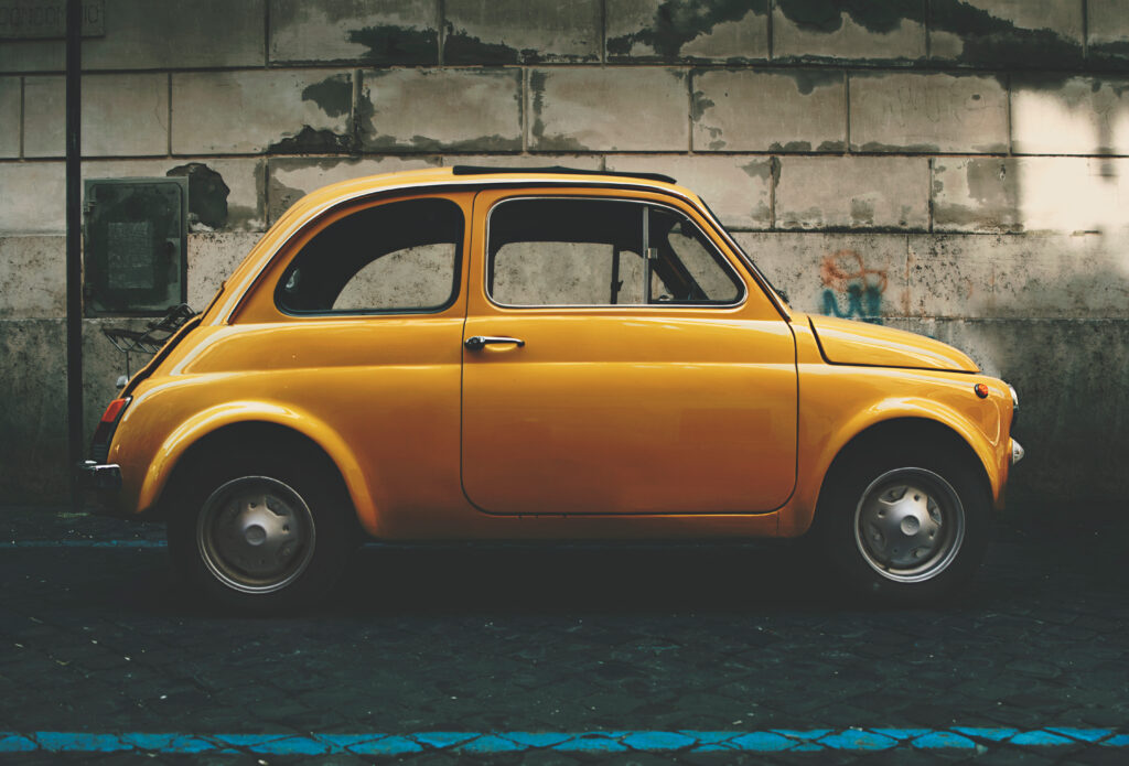 Vintage Yellow Car Wallpaper: Classic Urban Side View Scene