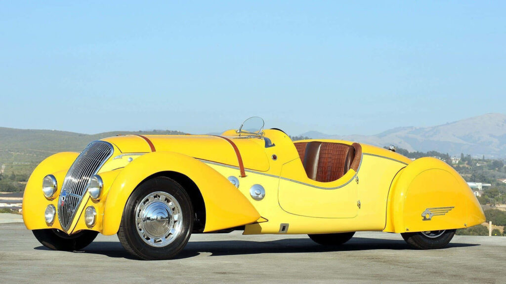 Sun-kissed Elegance: Capturing the Timeless Allure of a Vintage Yellow Ferrari with Luxurious Brown Leather Interior Wallpaper
