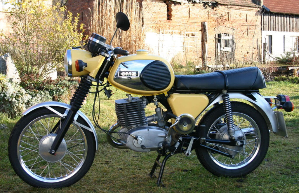 Vintage Yellow MZ Motorcycle Wallpaper Amidst Rustic Countryside