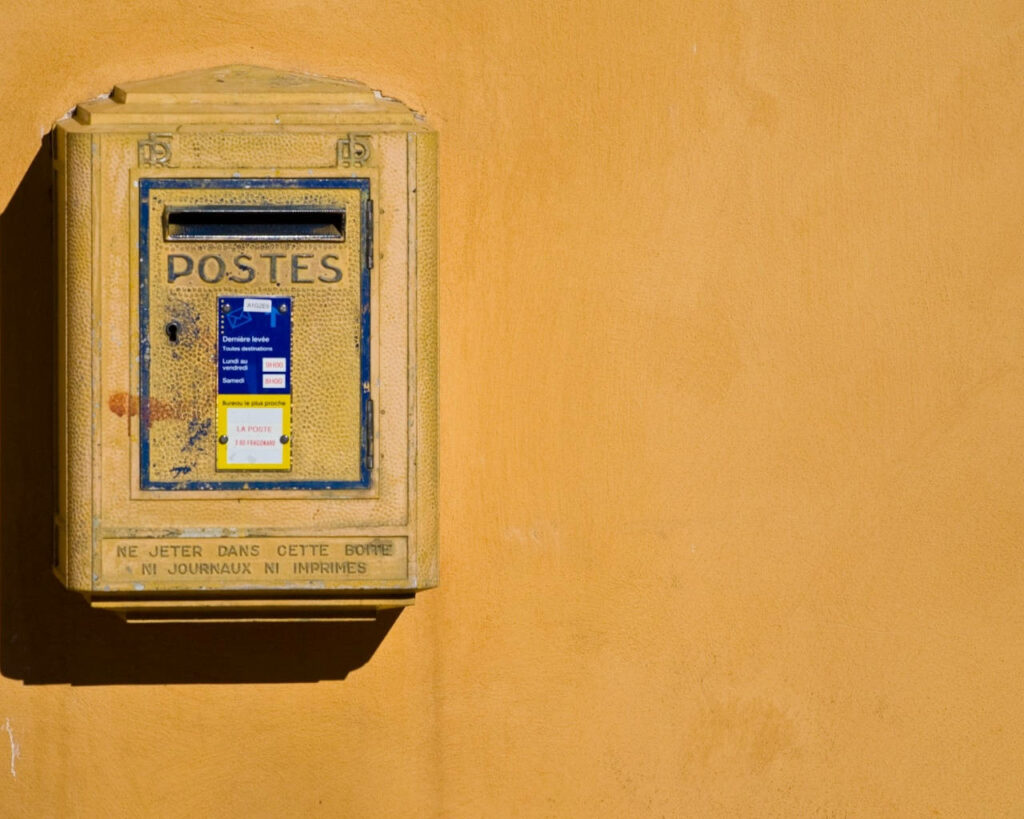 Vintage Yellow Mailbox on Warm Stucco Wall - Rustic European Decor Wallpaper