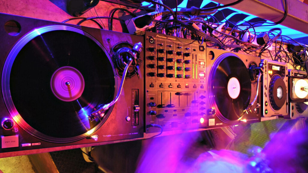 Spinning Vinyls and Colorful Lights: A DJ's Setup for the Perfect Mix Wallpaper