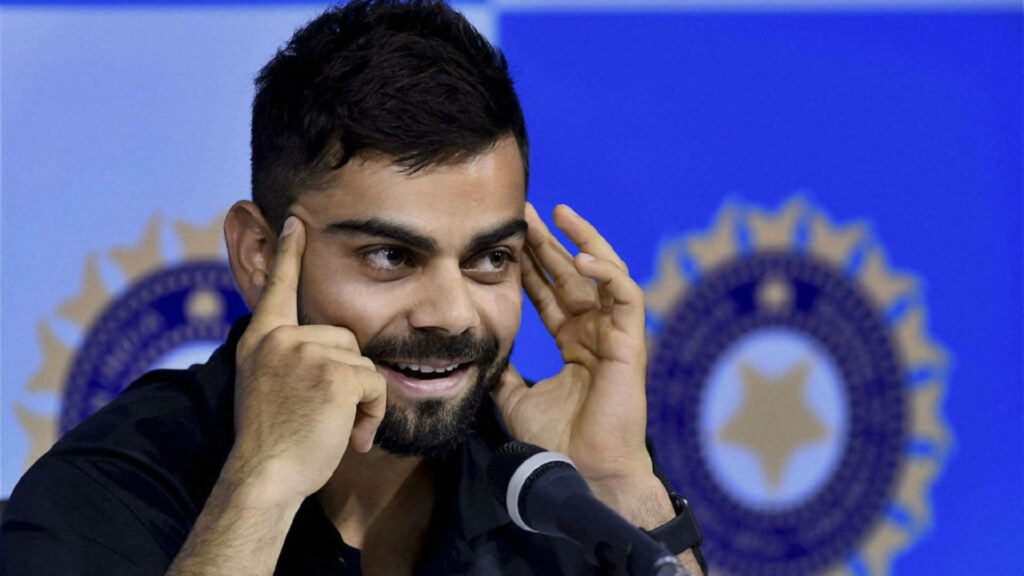 Virat Kohli smiling during an interview with BCCI logo background dynamic wallpaper image
