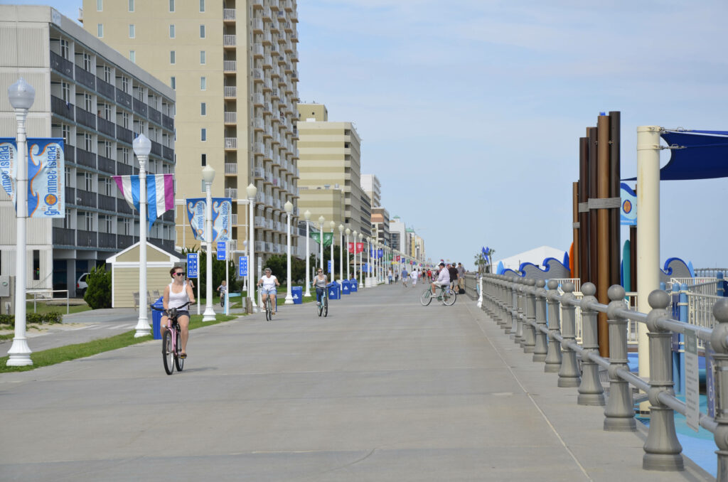 Virginia Beach Boardwalk oceanfront path with cyclists pedestrians hotels and colorful banners Wallpaper