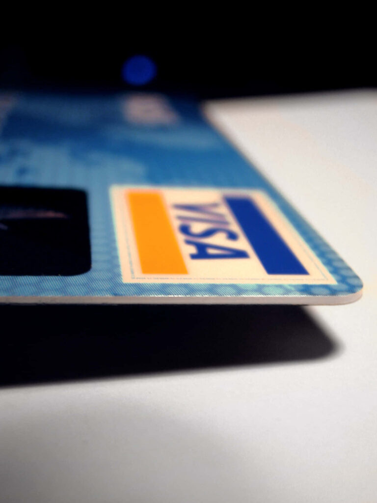 Close-up of Visa credit card with blue tones highlighting modern secure payment technology wallpaper