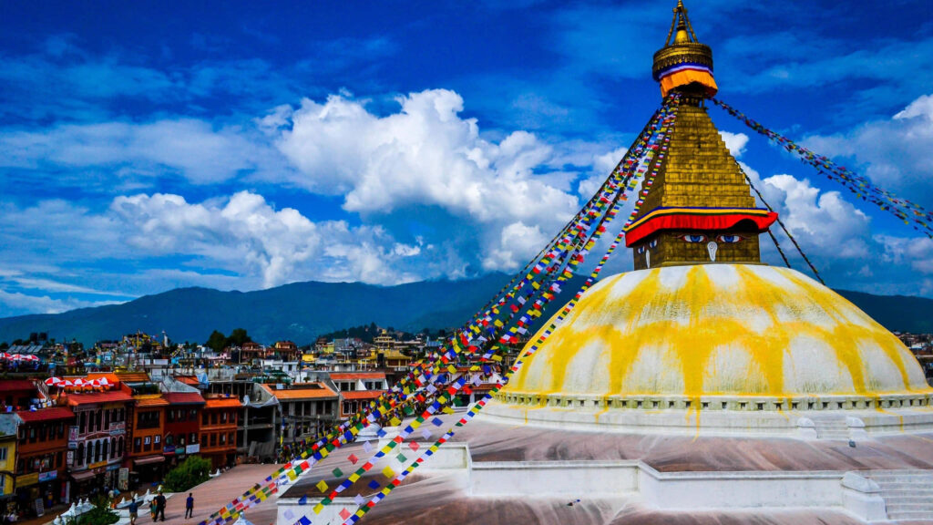 Vivid oversaturated Boudhanath Stupa Kathmandu Nepal colorful prayer flags blue sky clouds Wallpaper