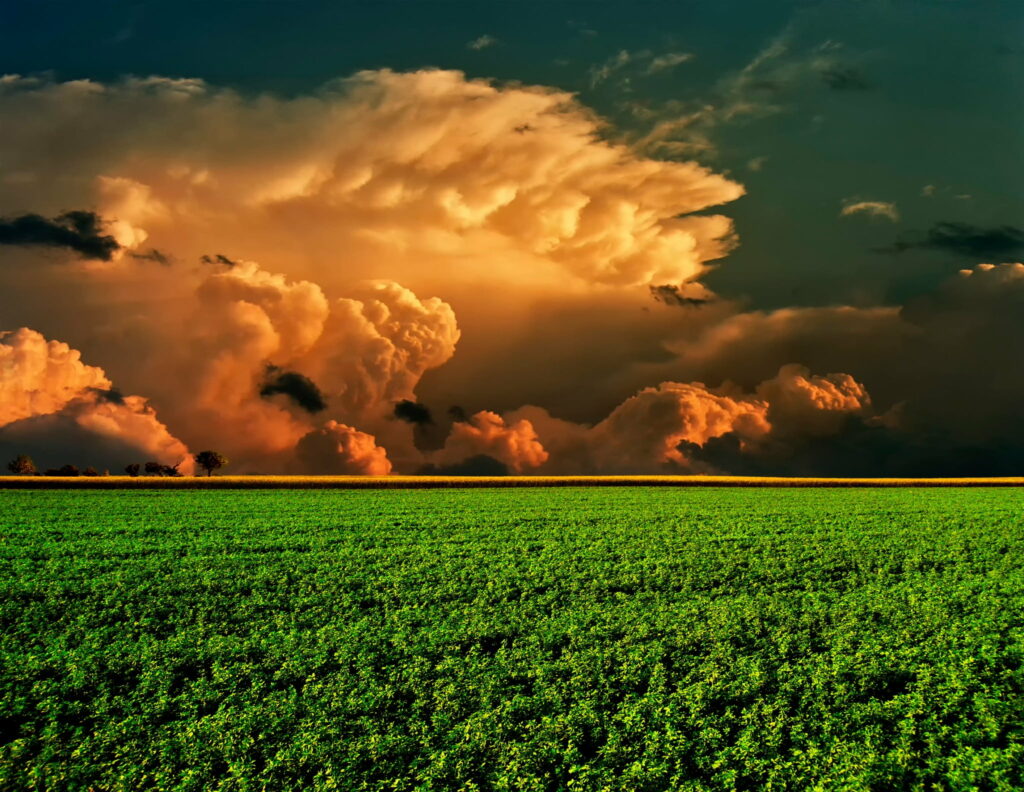 Stunning HD Wallpaper: Vast Green Field & Dramatic Orange Storm Clouds