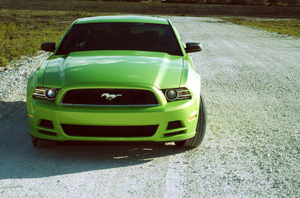 Vivid Lime Green Ford Mustang V6 in Rugged Landscape - Wallpaper