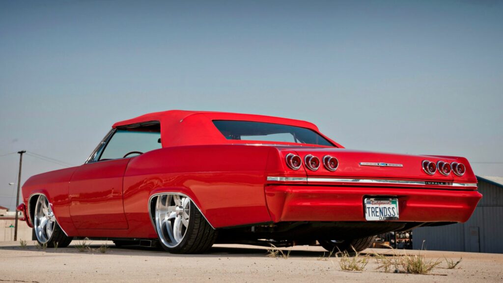 Sleek 1965 Red Chevrolet Impala Wallpaper Against Clear Sky