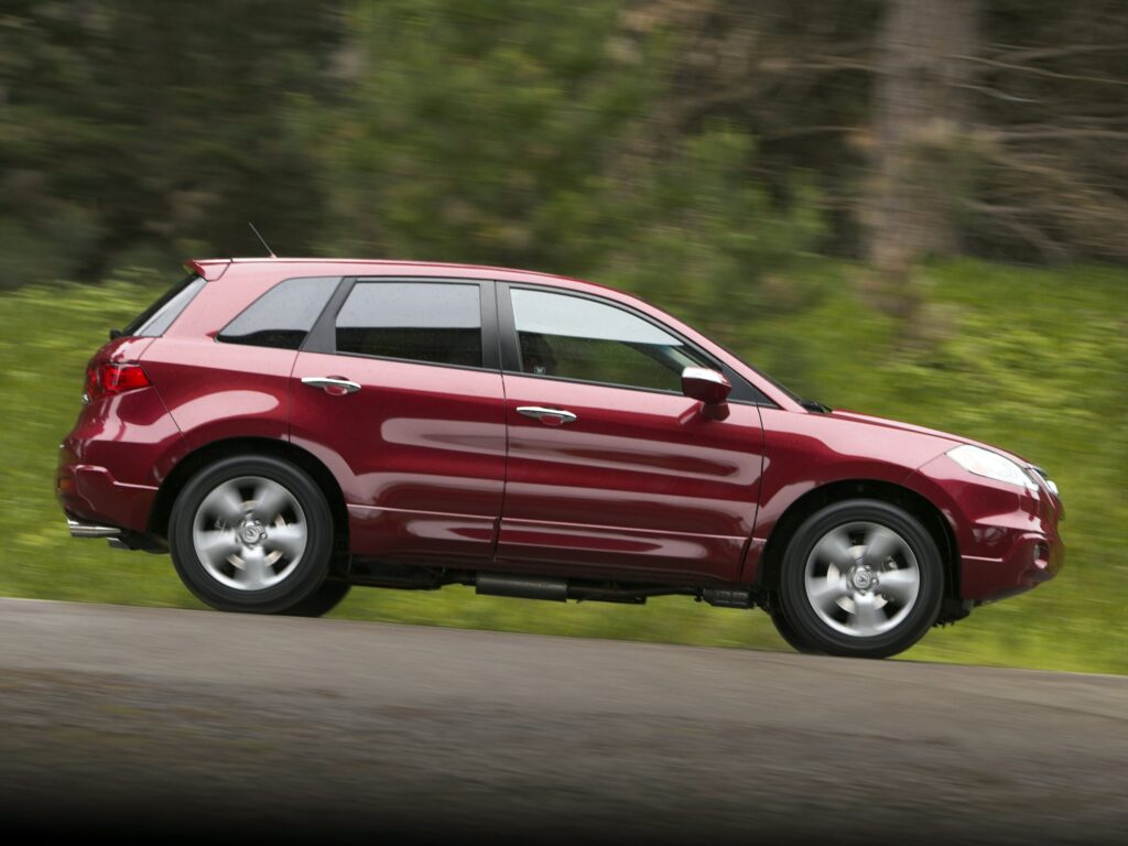 Red Acura RDX in Motion: Sleek Design Against Lush Green Background Wallpaper