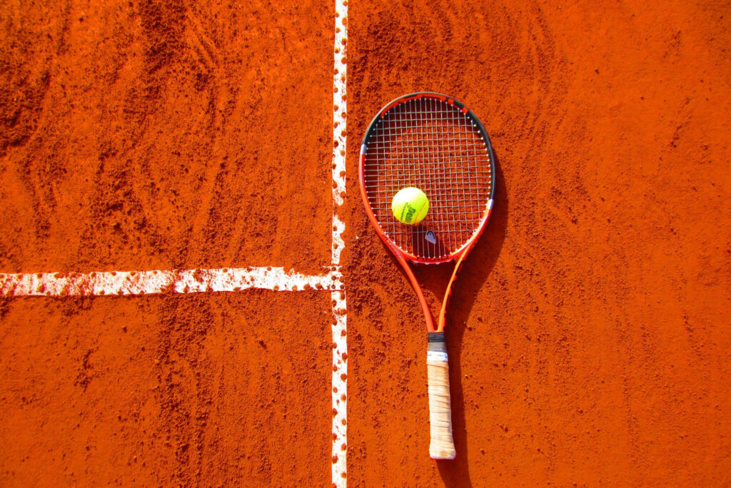 Vivid Squash Racket & Ball on Orange Floor - Sporty Wallpaper Design