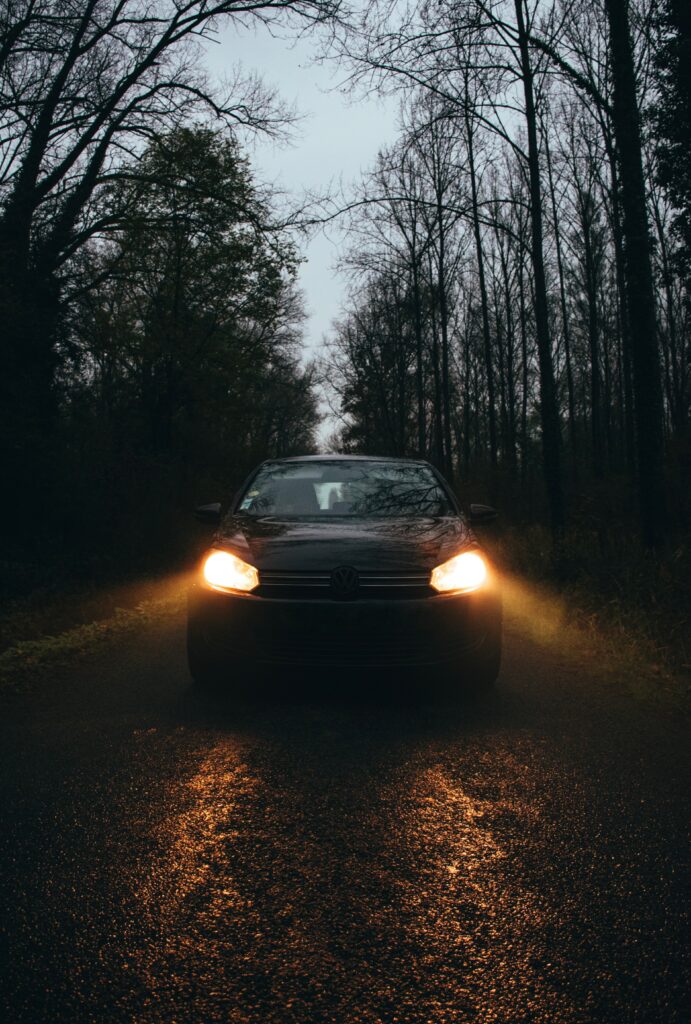 Volkswagen Car Illuminating Dark Tree-Lined Road Wallpaper