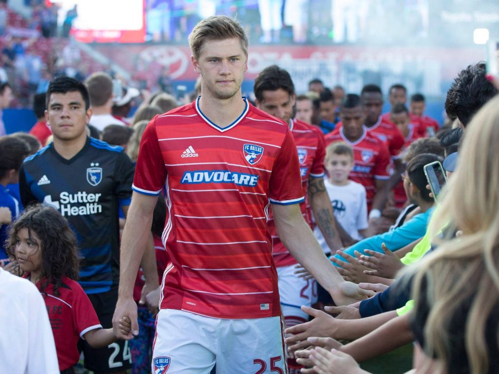 Walker Zimmerman MLS defender walking on pitch in red white FC Dallas jersey high-fiving fans Wallpaper