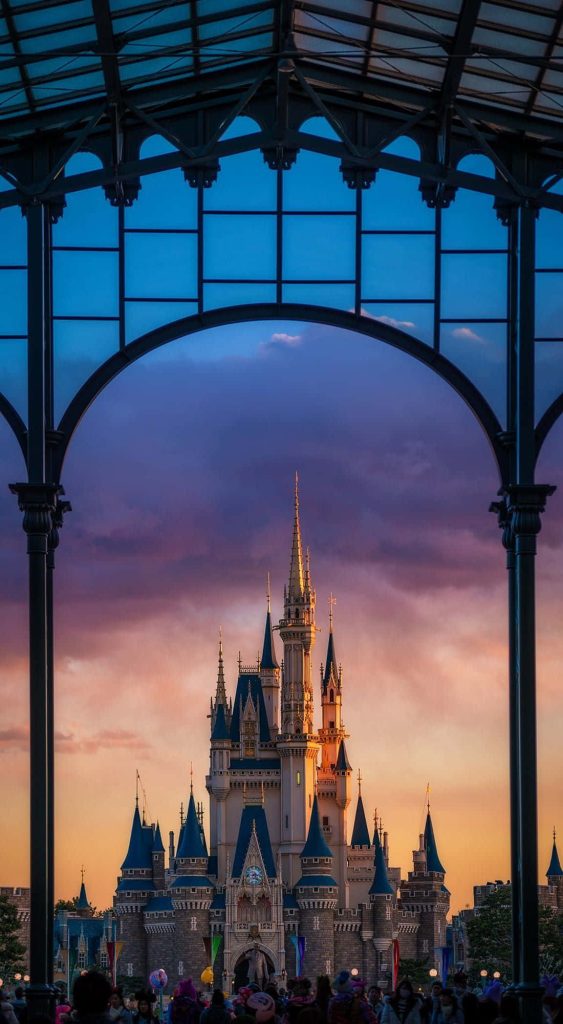 Walt Disney World Cinderella Castle at sunset framed by arch with vibrant twilight sky wallpaper