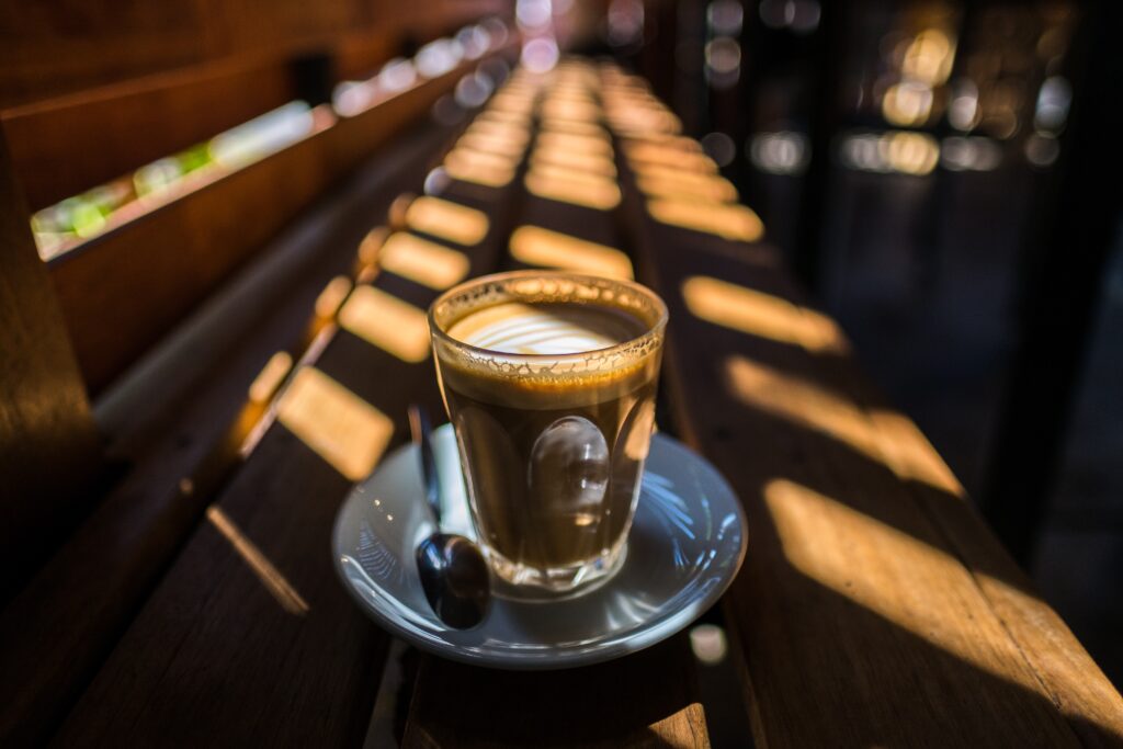 Cozy Cafe Wallpaper: Coffee on Wooden Table with Natural Light