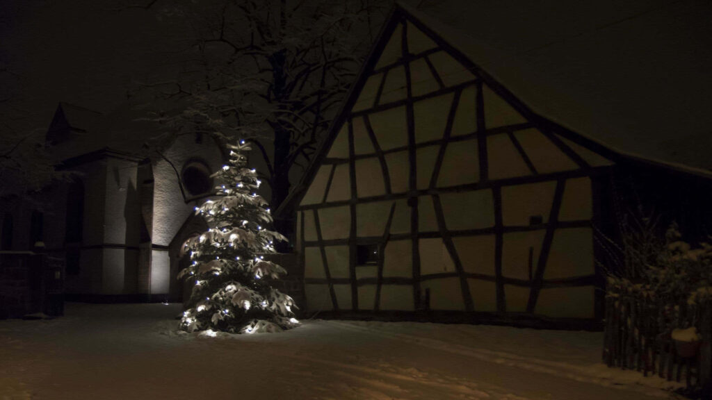 Cozy Christmas Tree in Snowy Timber House Background Wallpaper