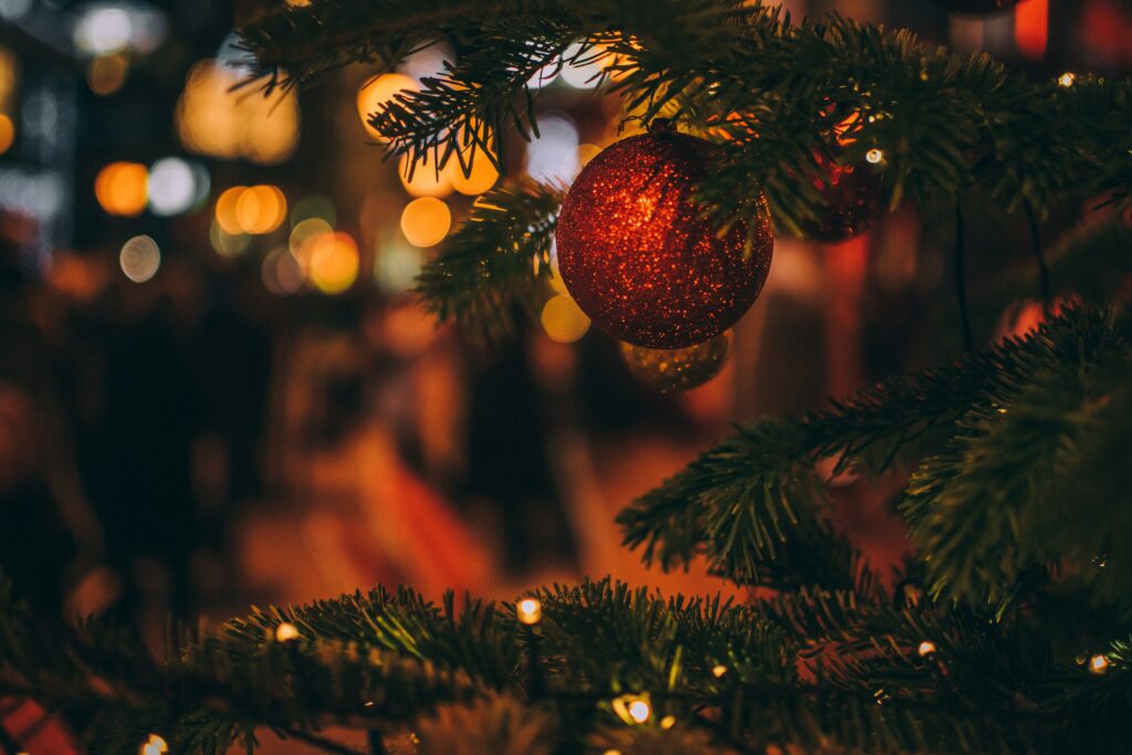 Cozy Christmas Tree Wallpaper with Red Glitter Ornament Background
