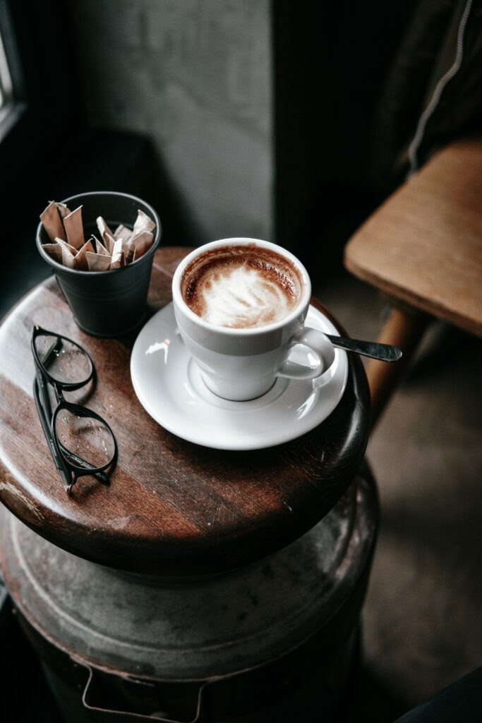 Cozy Coffee Scene: Cup, Glasses, & Sugar on Wooden Table Wallpaper