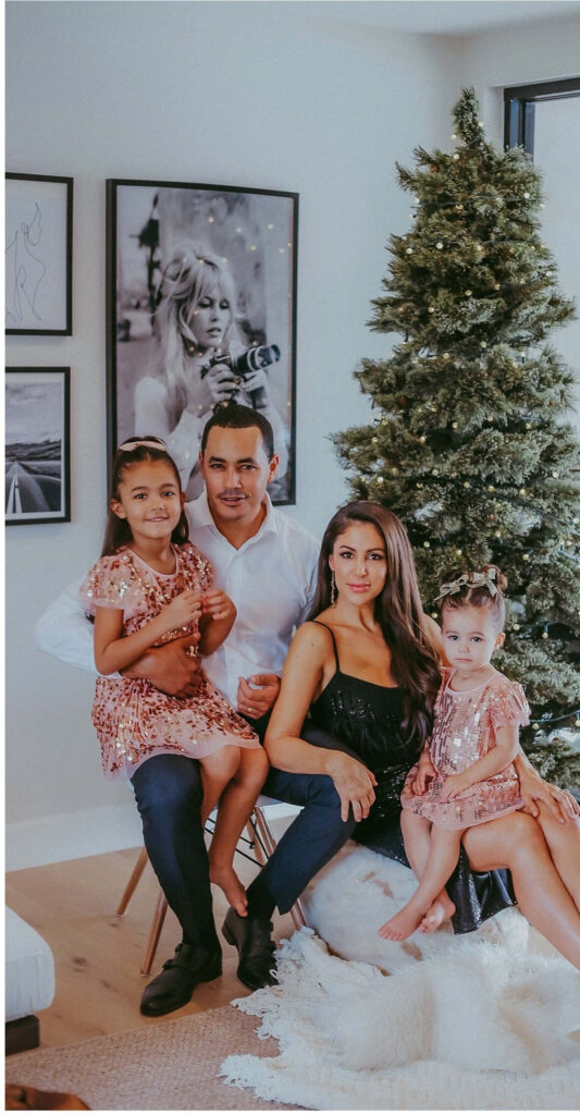 Joyful Family Portrait by a Beautifully Decorated Christmas Tree Wallpaper