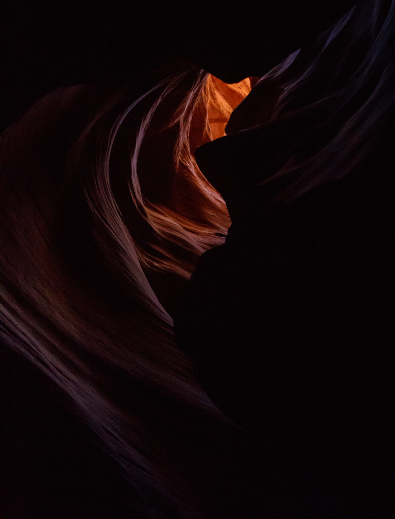 Sandstone cave interior with warm orange light highlighting textured natural rock formations Wallpaper
