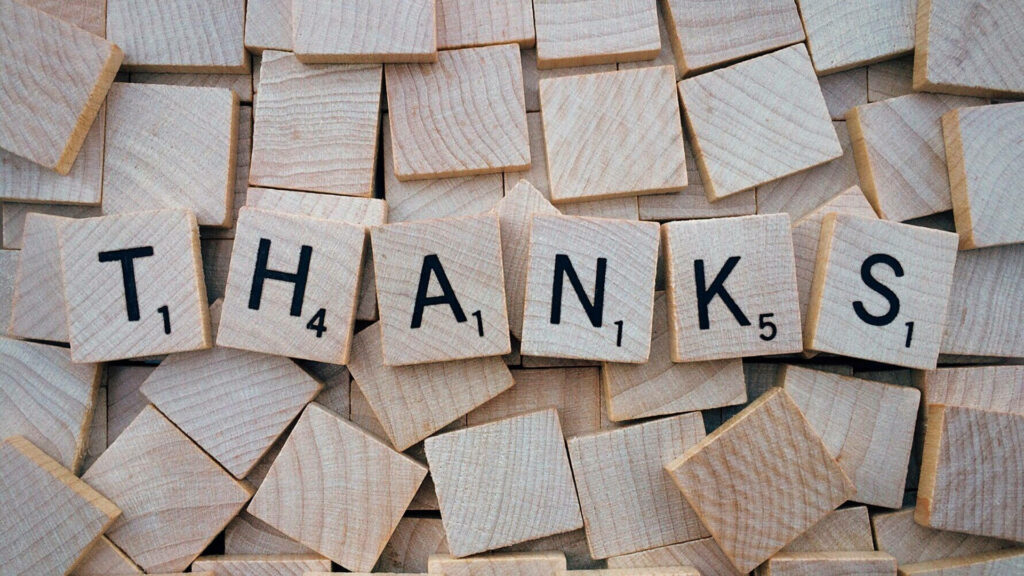 Scrabble Tile 'THANKS' on Wooden Block Background Wallpaper