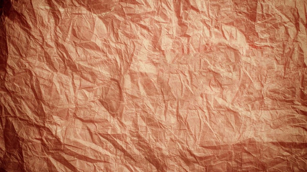 Warm terracotta crumpled paper wallpaper with rich orange hues and rustic textured folds background