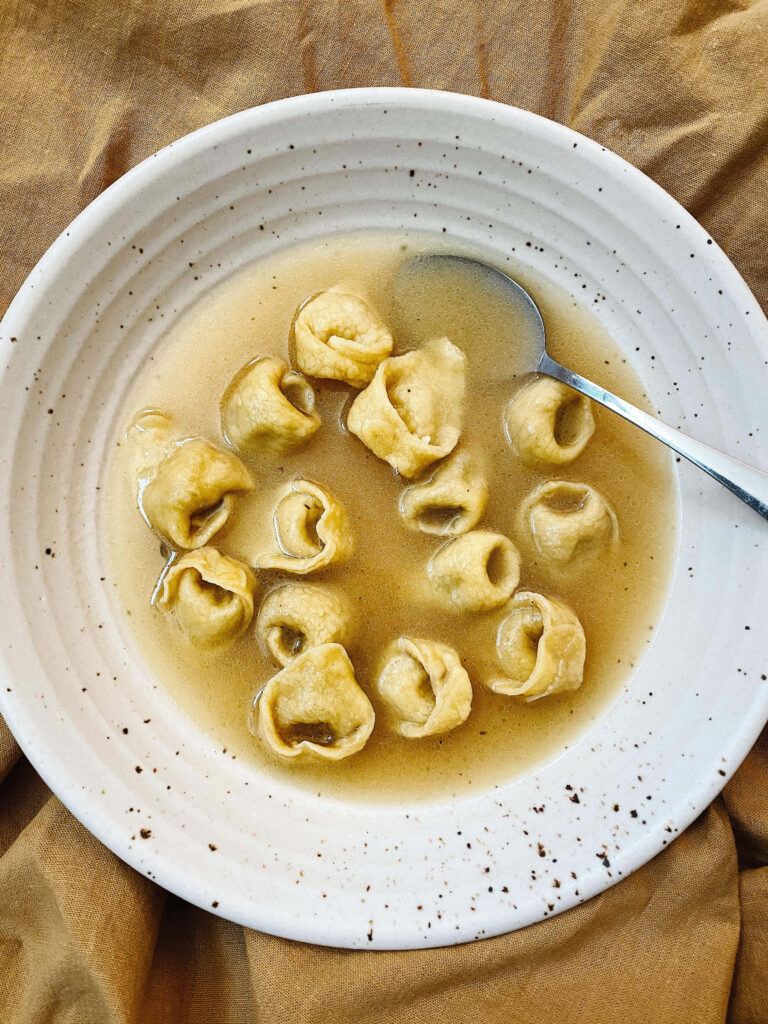 Warm Tortellini in Brodo Wallpaper: Inviting Rustic Plate Design