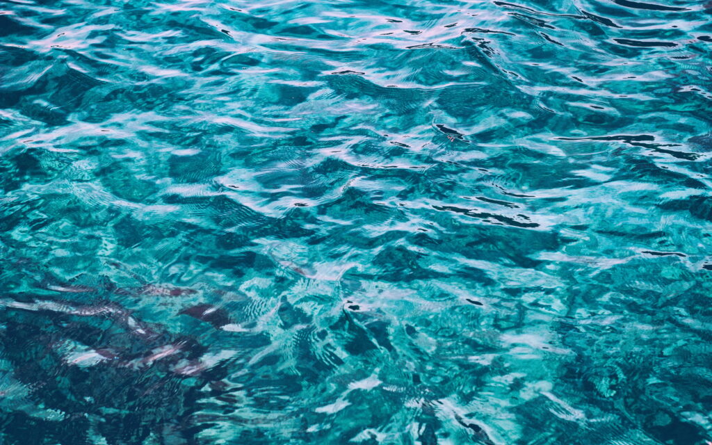 Macro 4K wallpaper of crystal-clear blue water with vibrant turquoise ripples and ocean hues