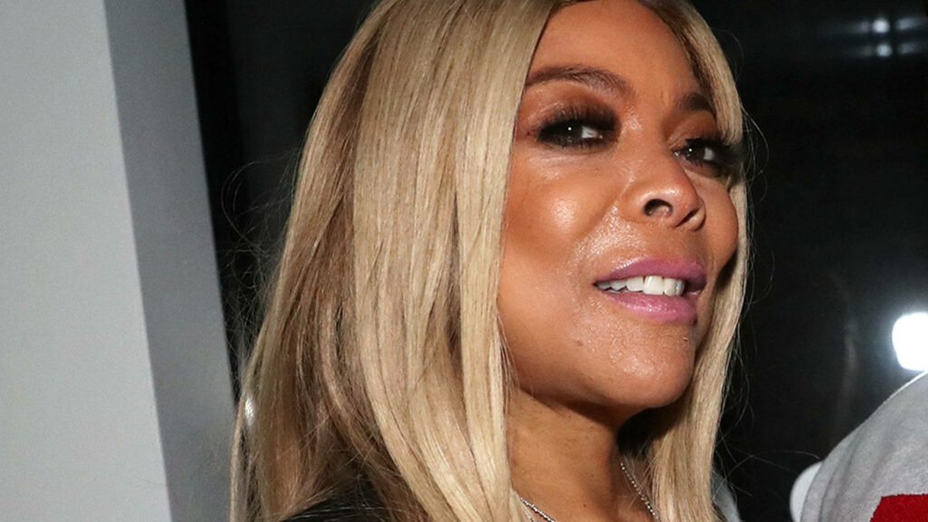 Sideways closeup of Wendy Williams with long blonde hair and confident expression wallpaper background