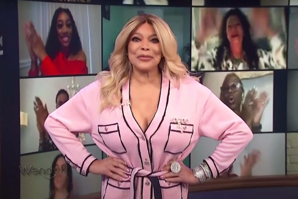 Wendy Williams in pink robe with virtual audience cheering on screens lively talk show wallpaper