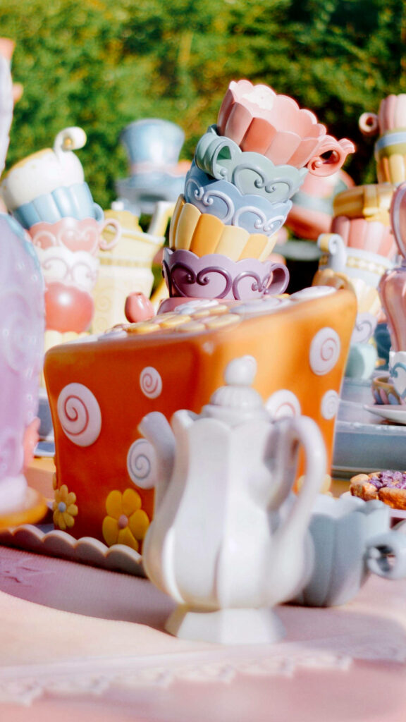 Whimsical Alice in Disneyland wallpaper with colorful teacups playful teapot pastel tea party