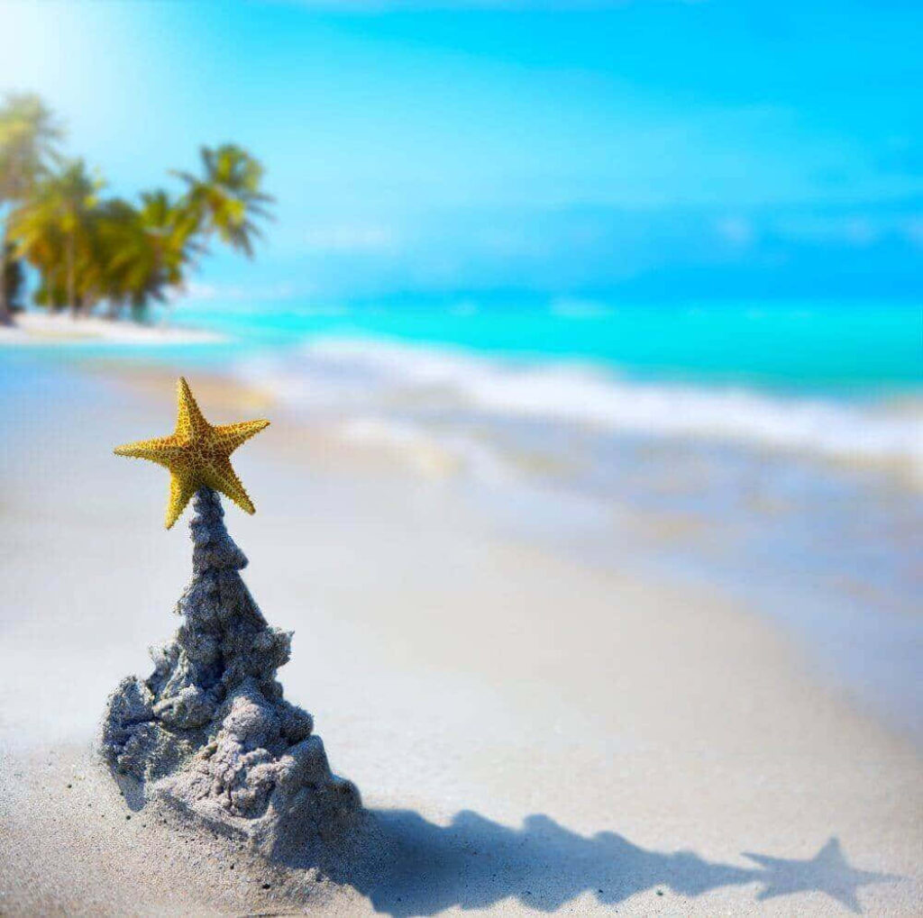Whimsical Tropical Beach Wallpaper: Christmas Tree Sandcastle Scene