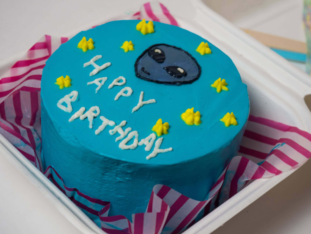 Whimsical Birthday Cake Wallpaper with Blue Frosting & Alien Fun