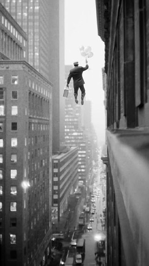 Whimsical Black and White Wallpaper: Man with Balloons Over City