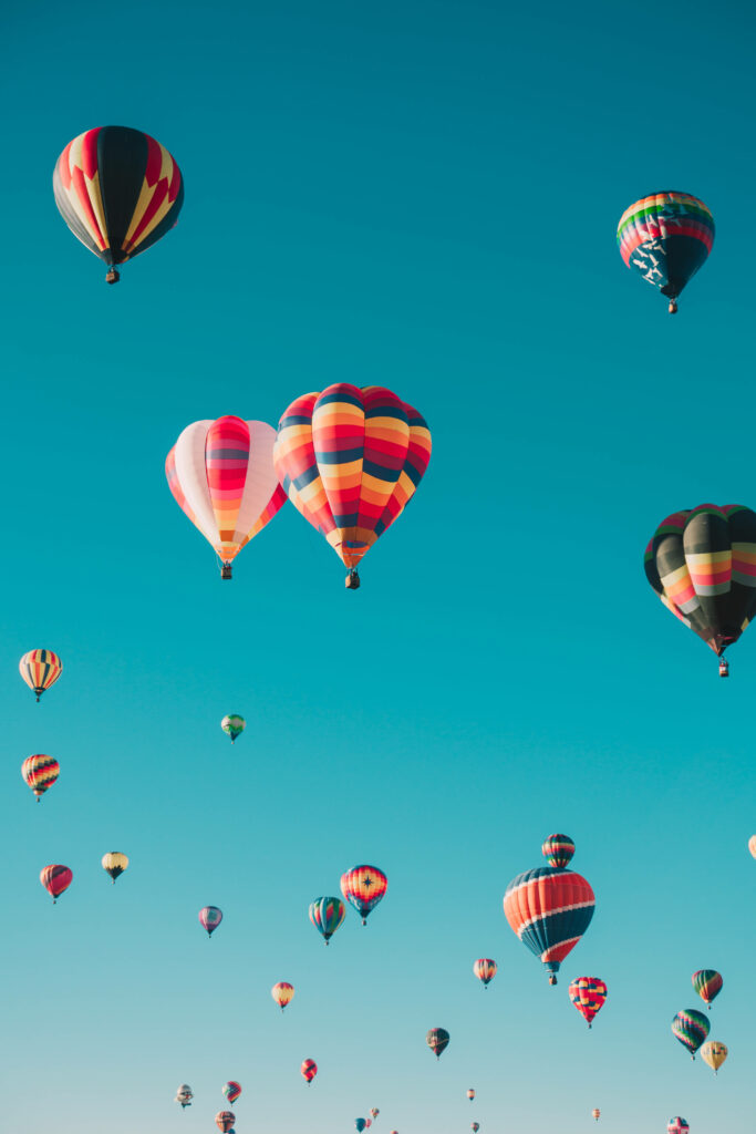 Whimsical Blue Sky Wallpaper with Colorful Hot Air Balloons