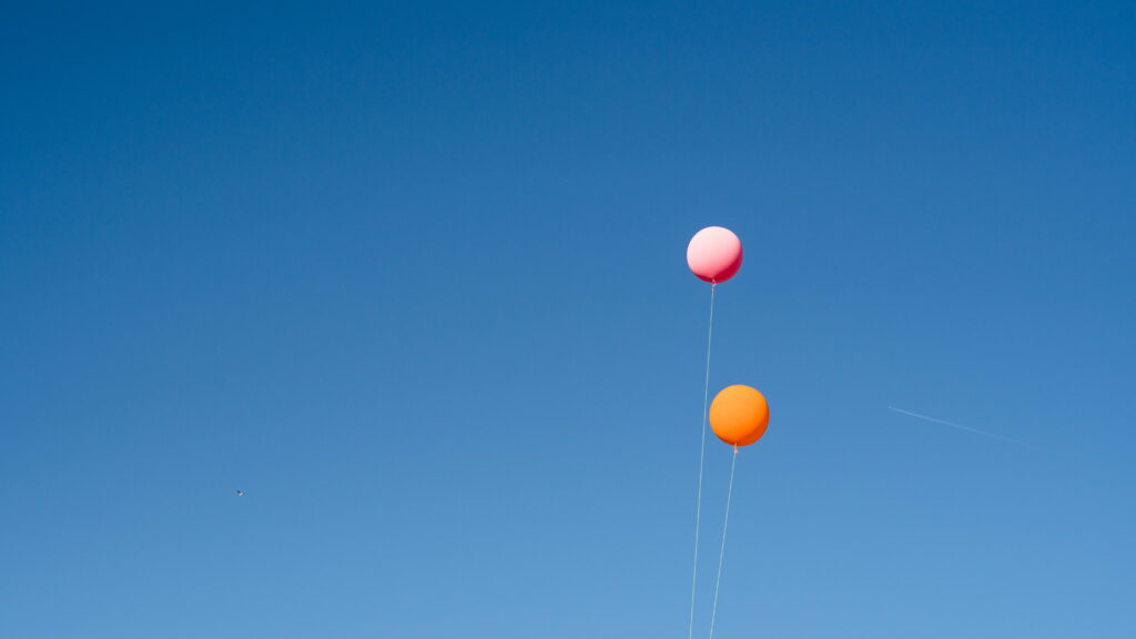 Bursts of Vibrant Color: A Captivating 4K Wallpaper featuring Orange and Pink Balloons