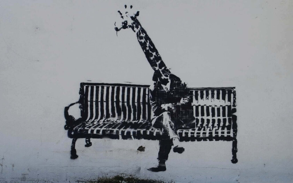 Whimsical Giraffe Graffiti Wallpaper: Surreal Park Bench Art