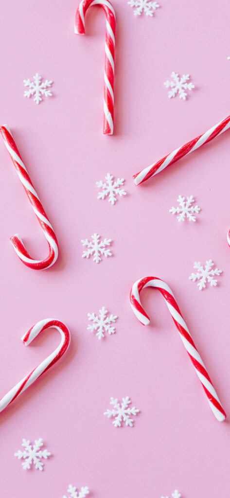 Whimsical Candy Cane and Snowflake Wallpaper on Soft Pink Background