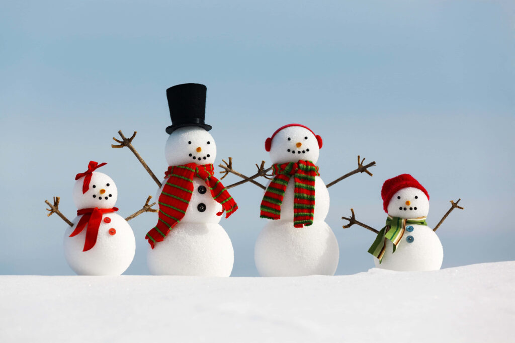 Whimsical Winter Scene: Four Charming Snowmen in Colorful Scarves Wallpaper