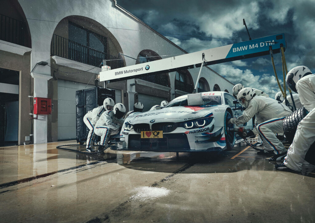 Revved-Up Respite: BMW M4 DTM Car Unleashing Power Amidst a Pit Stop at the Track Wallpaper
