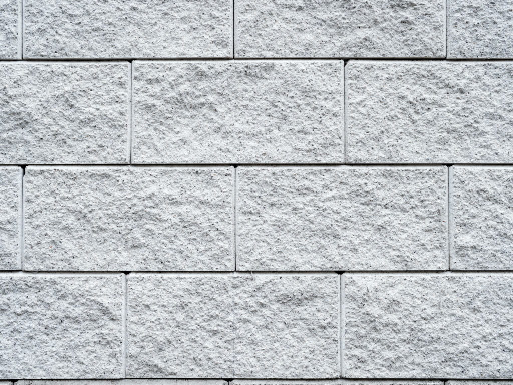 Rough & Ready: Close-Up Concrete Texture with White Brick Wallpaper Knockdown on Display
